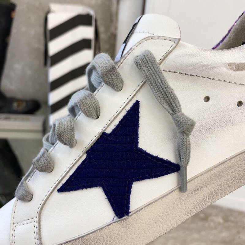 white S*per-star sneakers with blue star and glittery heel tab
