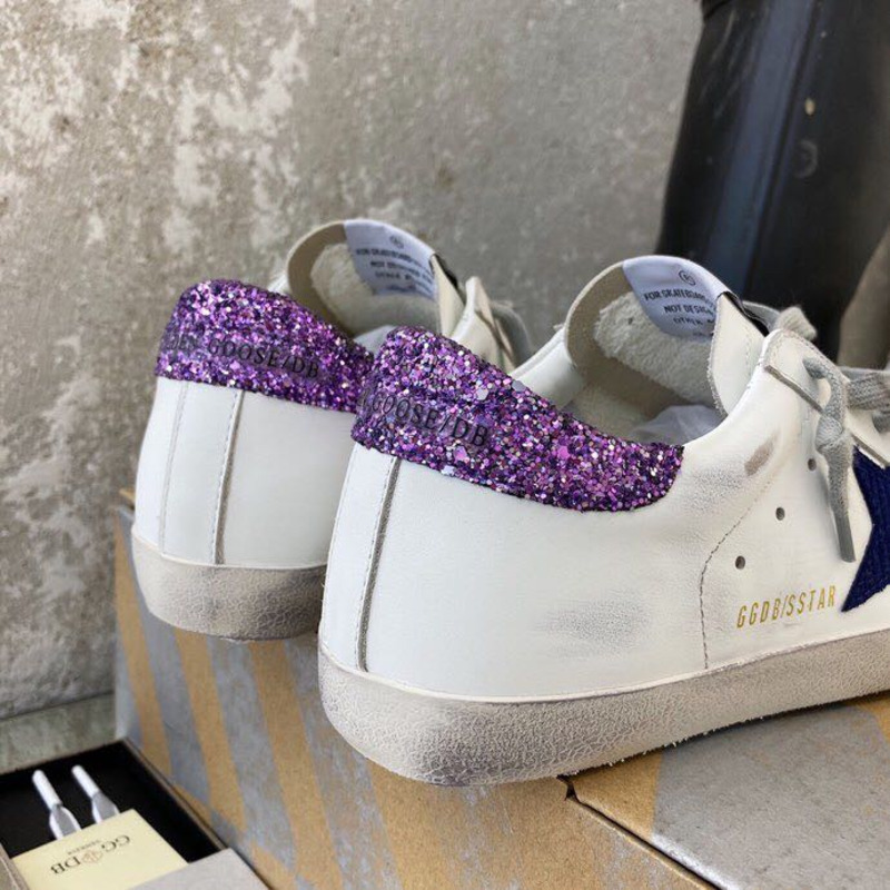 white S*per-star sneakers with blue star and glittery heel tab