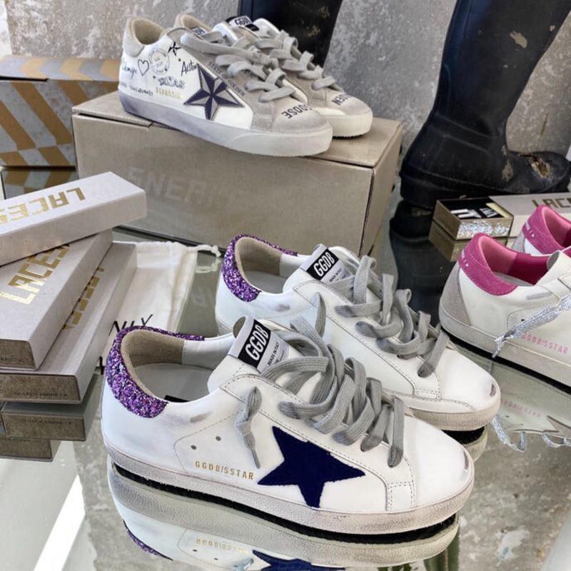 white S*per-star sneakers with blue star and glittery heel tab