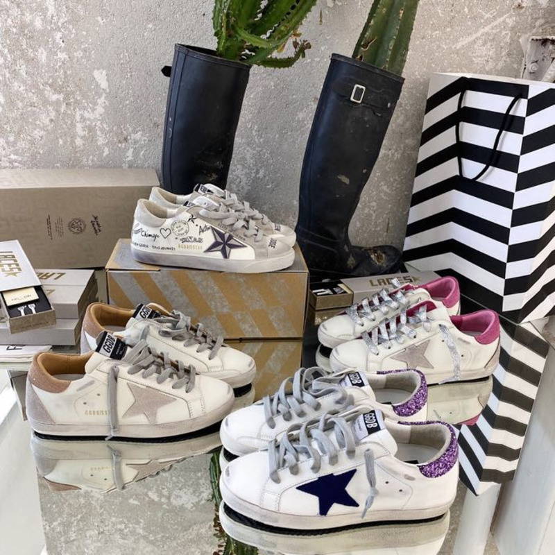 white S*per-star sneakers with blue star and glittery heel tab